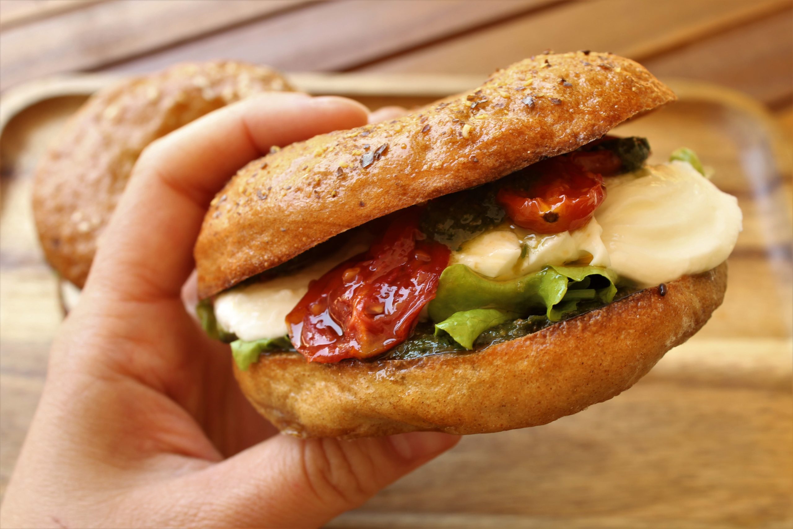 Bagel vegetariano con mozzarella, pesto e pomodorini confit