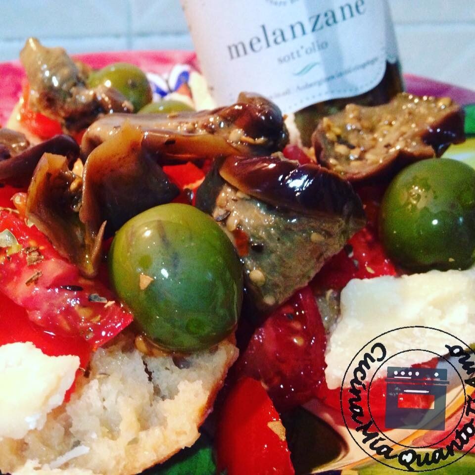 Biscotto di grano condito con pomodoro e melanzane sott’olio
