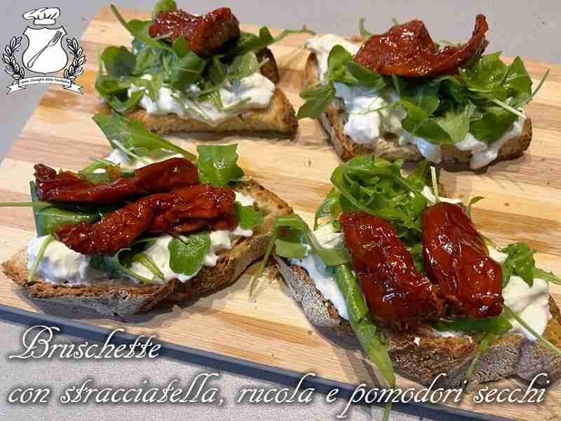 Bruschetta con stracciatella, rucola e pomodori secchi