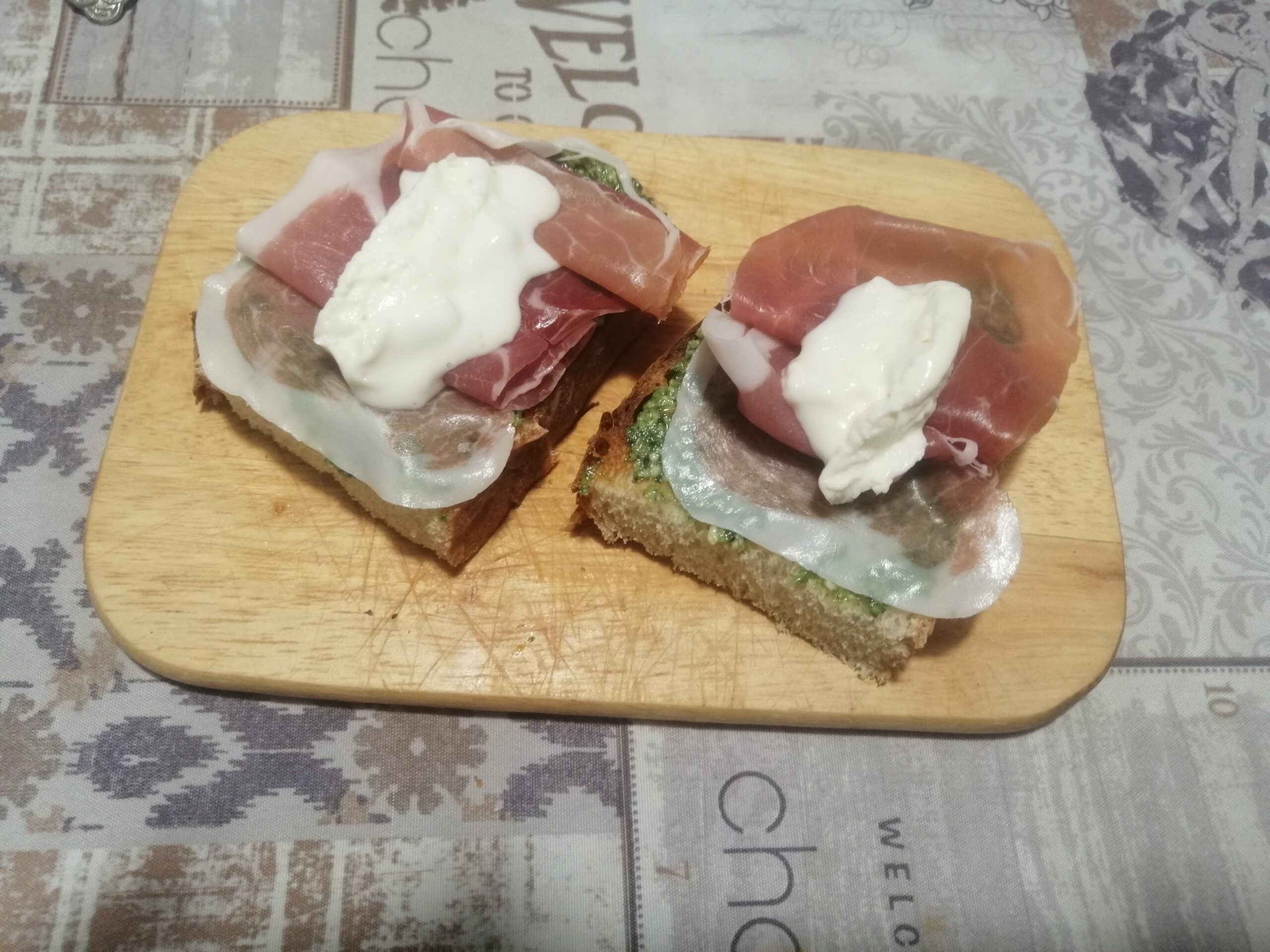 Bruschette crudo, squacquerone e pesto di rucola