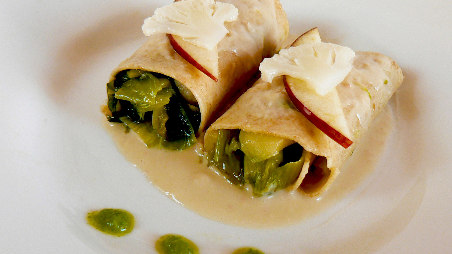 Cannelloni con farina di grano saraceno farciti con scarola, mele e cavolfiore, guarniti con crema di cannellini.