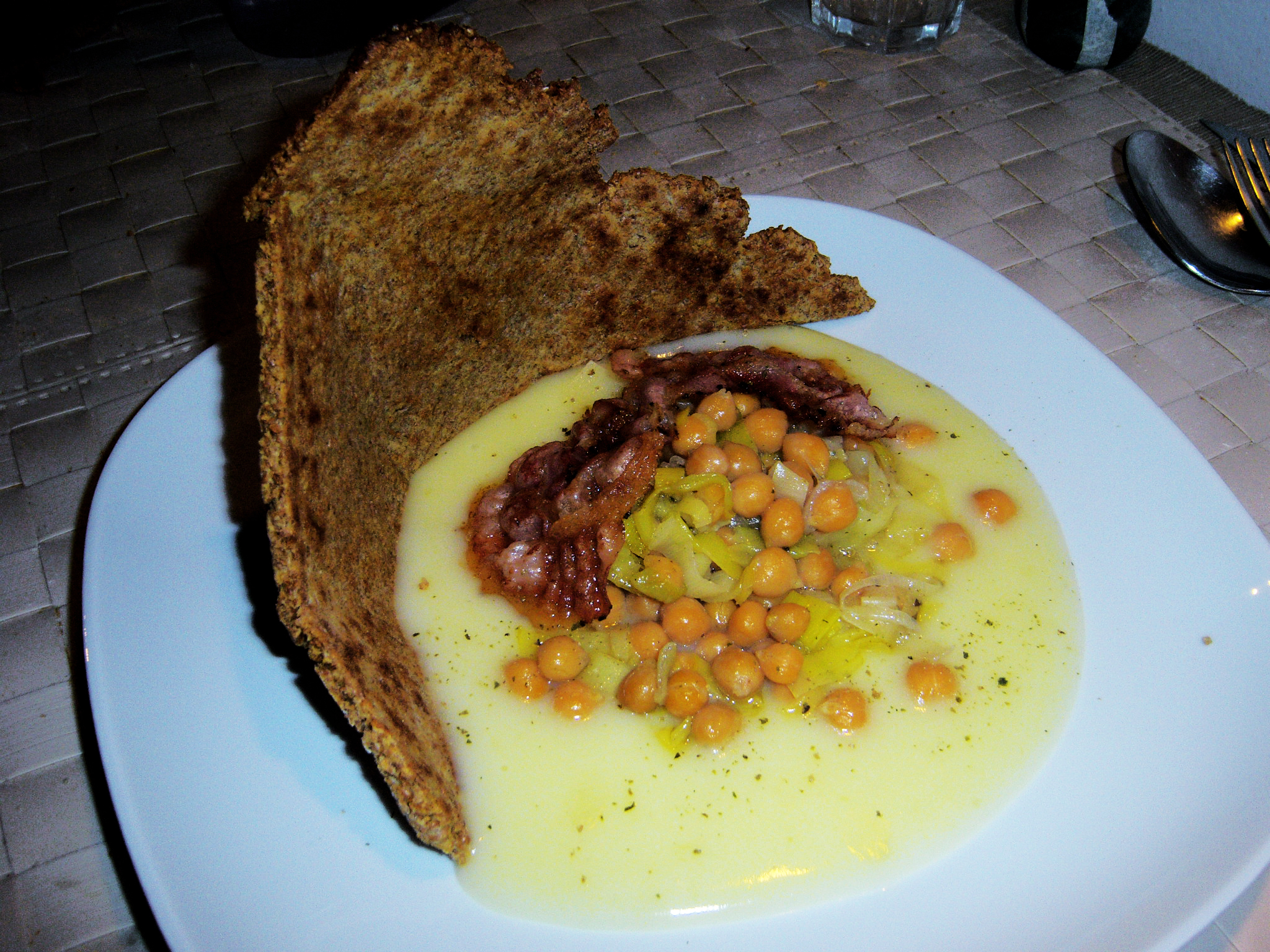 Ceci, porri e pancetta su crema di patate con piada di crusca
