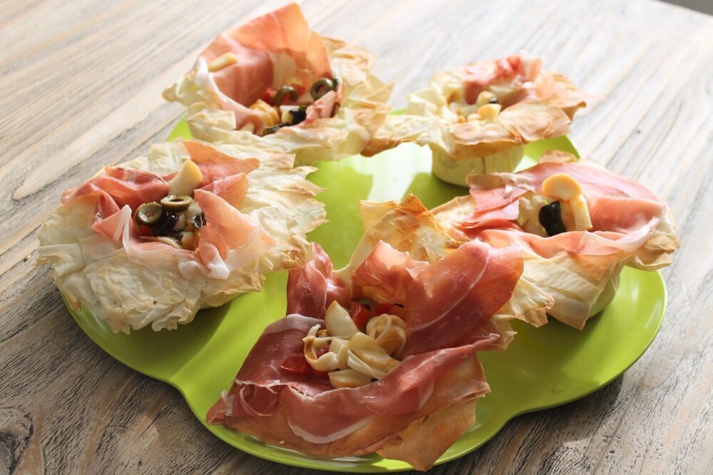 Cestini di pasta fillo al crudo, pomodorini, olive e scamorza