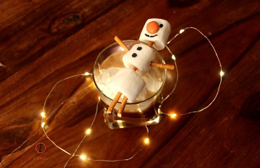 Cioccolata calda al caffè con panna montata e pupazzo di neve di marshmallow
