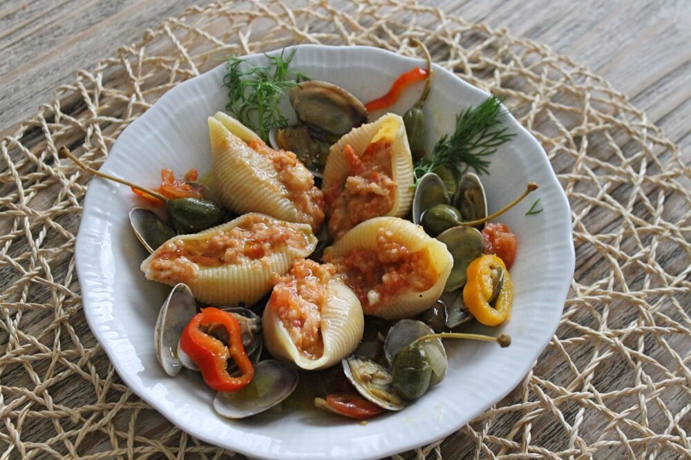 Conghiglioni ripieni di gamberi e pomodorini in zuppetta di vongole