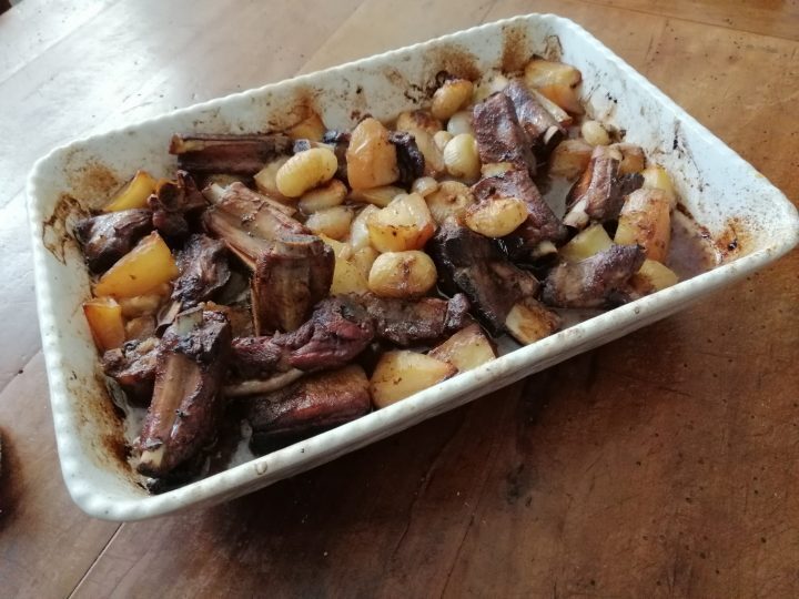 Costine di maiale al forno con patate e cipolline
