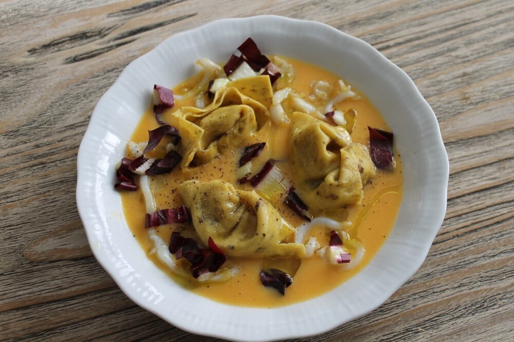 Crema di zucca con ravioloni di radicchio e seppie