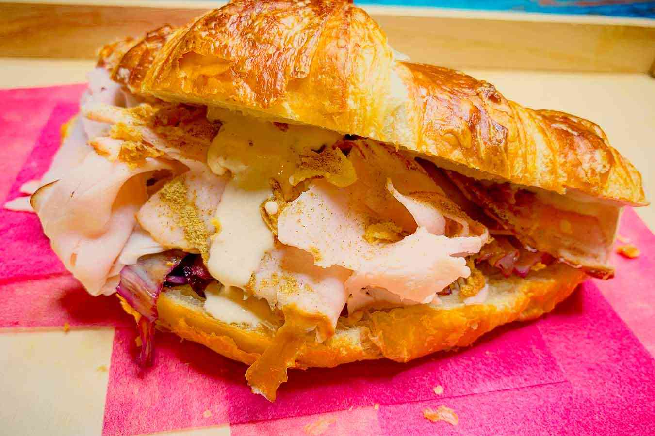 Croissant salato con tacchino, radicchio rosso, salsa tonnata e liquirizia