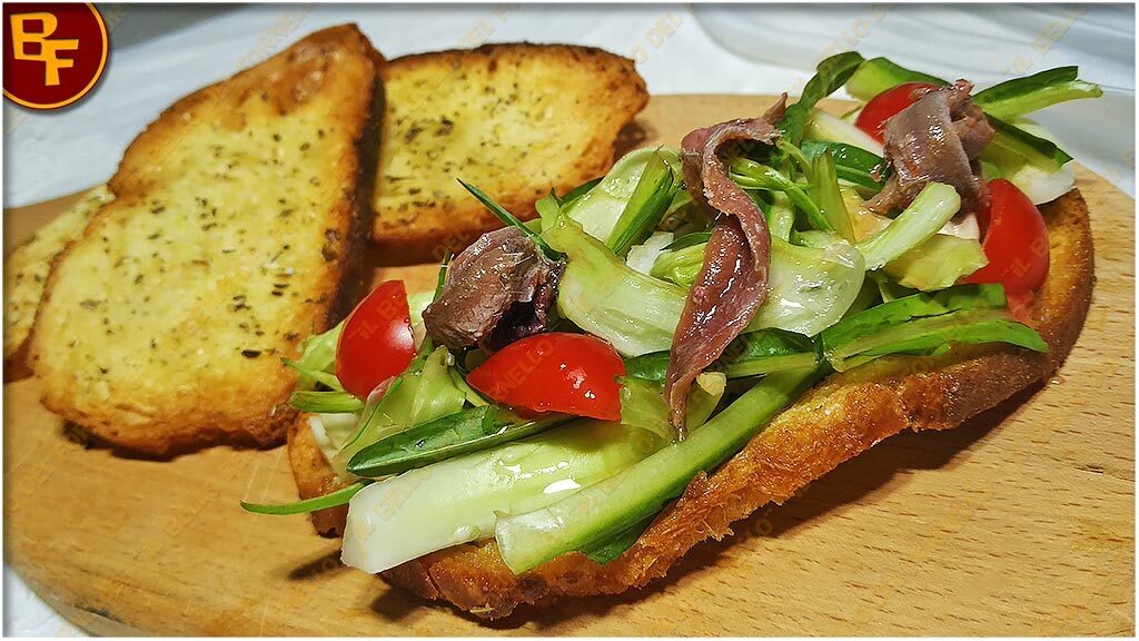 Crostini di pane con puntarelle e alici sott’olio