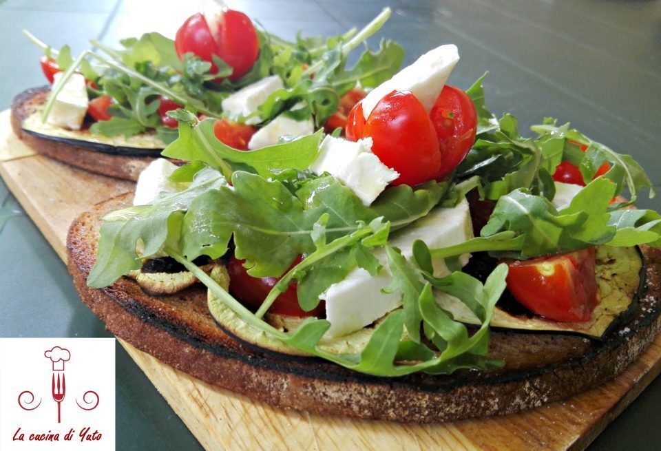 Crostini di pane di segale con rucola, feta e melanzana