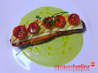 Crostone di pane con Asiago, julienne di cuori di carciofini sott’olio casarecci e pomodorini confit su crema di fave e ricotta