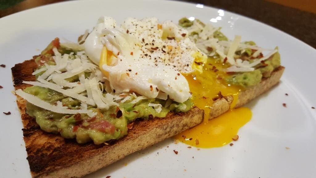 Crostone di pane toscano con guacamole, scaglie di grana e uovo in camicia