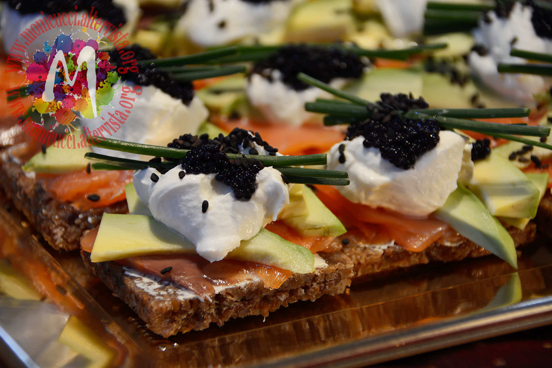 Crostoni di segale con salmone, panna acida, avocado e caviale
