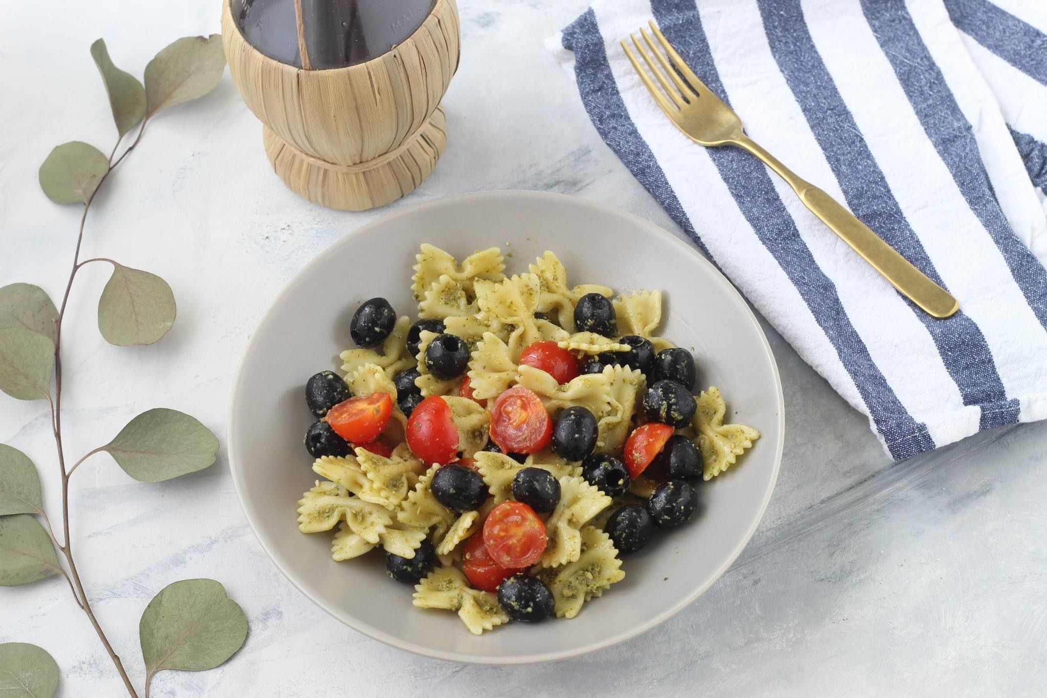 Farfalle con pesto di pistacchio, pomodorini e olive