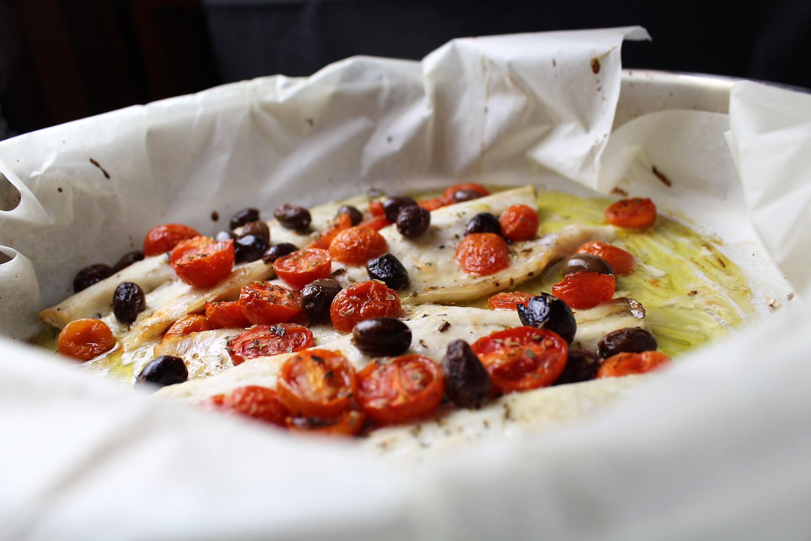 Filetti di branzino al forno con olive taggiasche e pomodorini