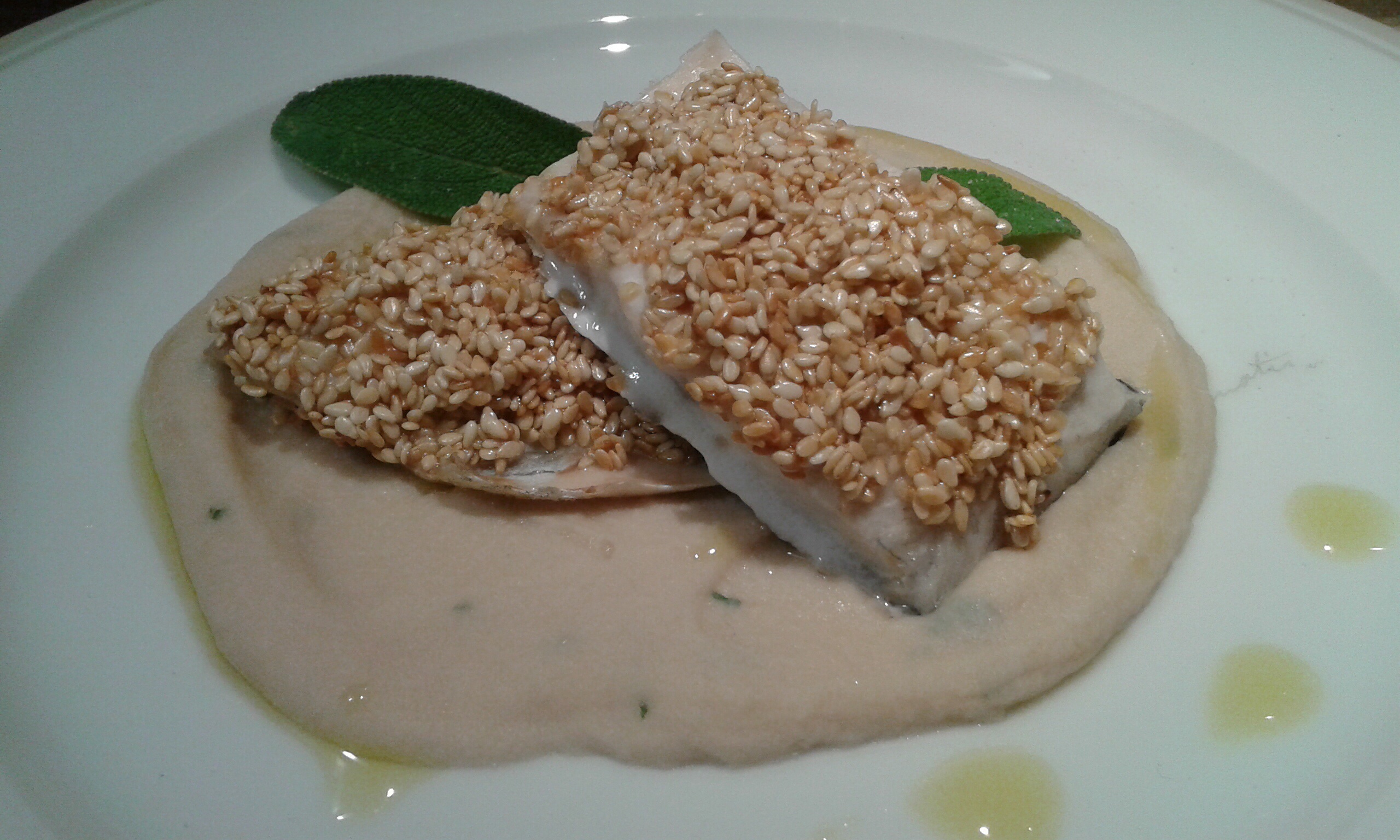 Filetti di branzino in crosta di sesamo su purea di cannellini