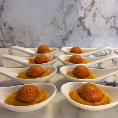 Finger food di sfere di pane pomodoro e olive su crema di peperoni profumati allo zenzero