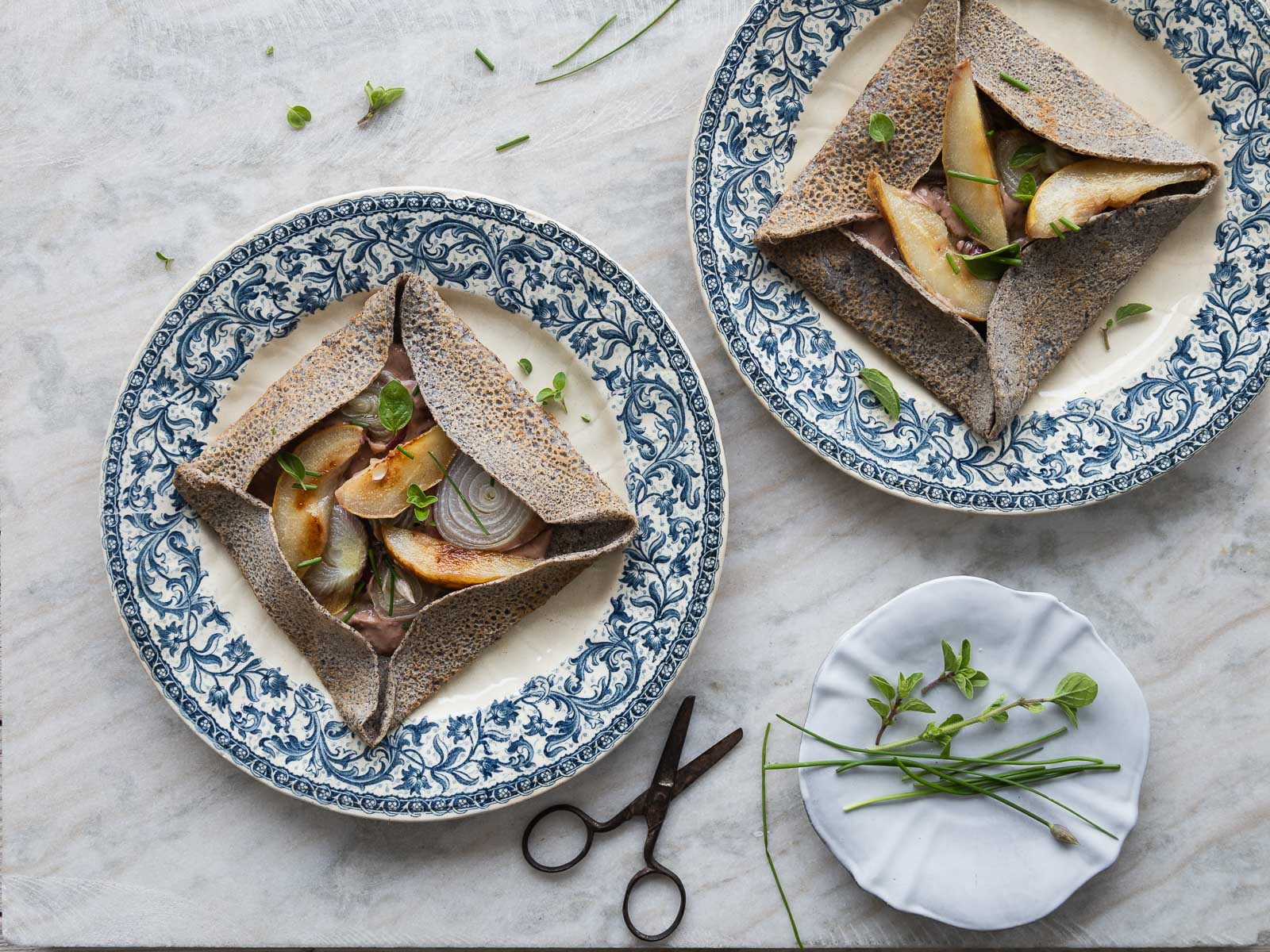 Galette bretonne con hummus, cipolle rosse e pere grigliate.