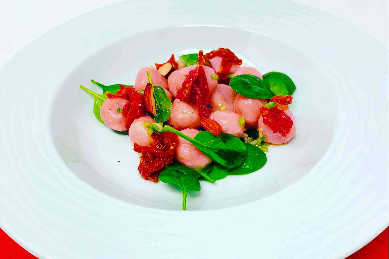 Gnocchi rosa di barbabietola, con spinacini e pomodorini secchi