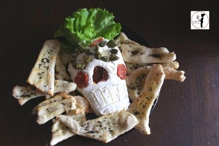 Halloween: teschio di formaggio con cracker di pasta matta e semi di sesamo in friggitrice ad aria