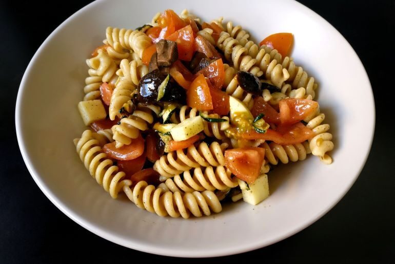 Insalata di pasta fredda con pomodorini, provola e olive nere