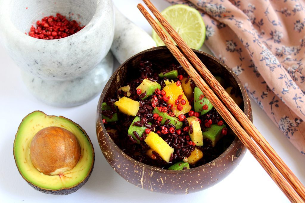 Insalata di riso venere con frutta tropicale e pepe rosa