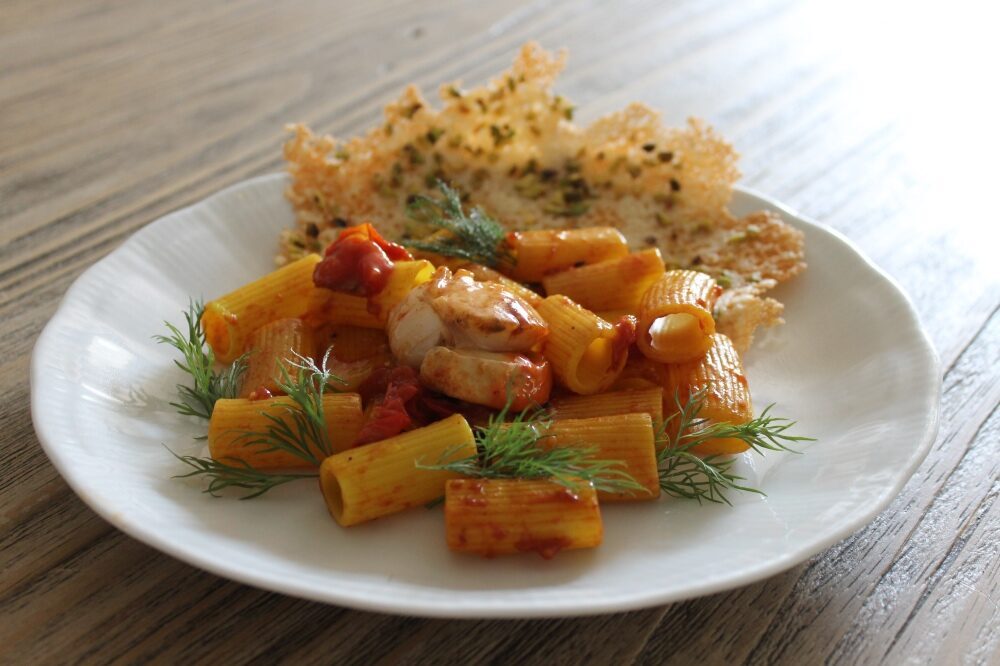 Mezze maniche pomodorini e capesante su cialda di pecorino e pistacchi