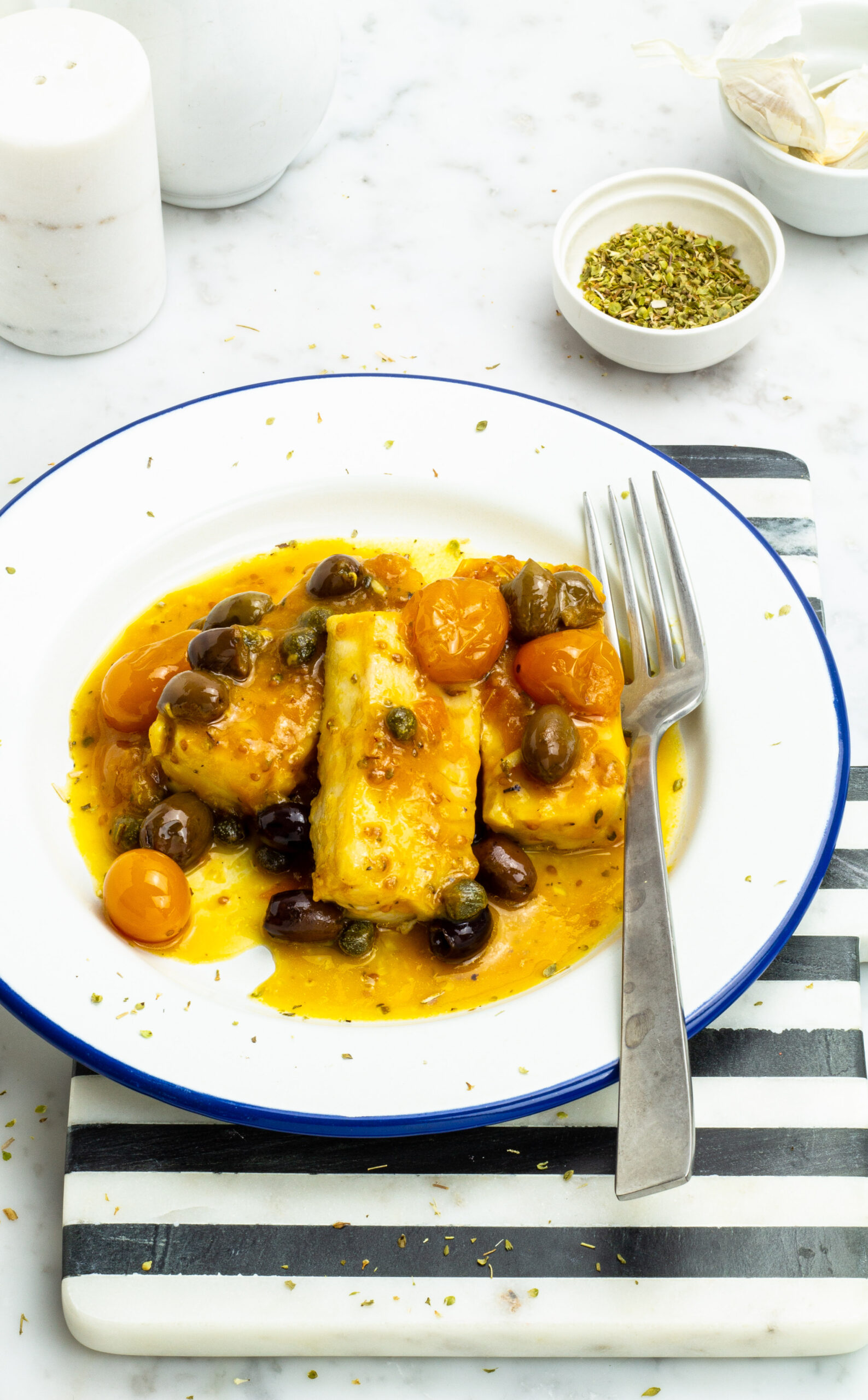Nasello con pomodorini, capperi e olive