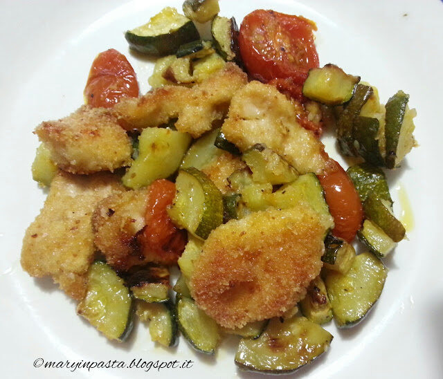 Nuggets di pollo al forno su letto di pomodorini e zucchine