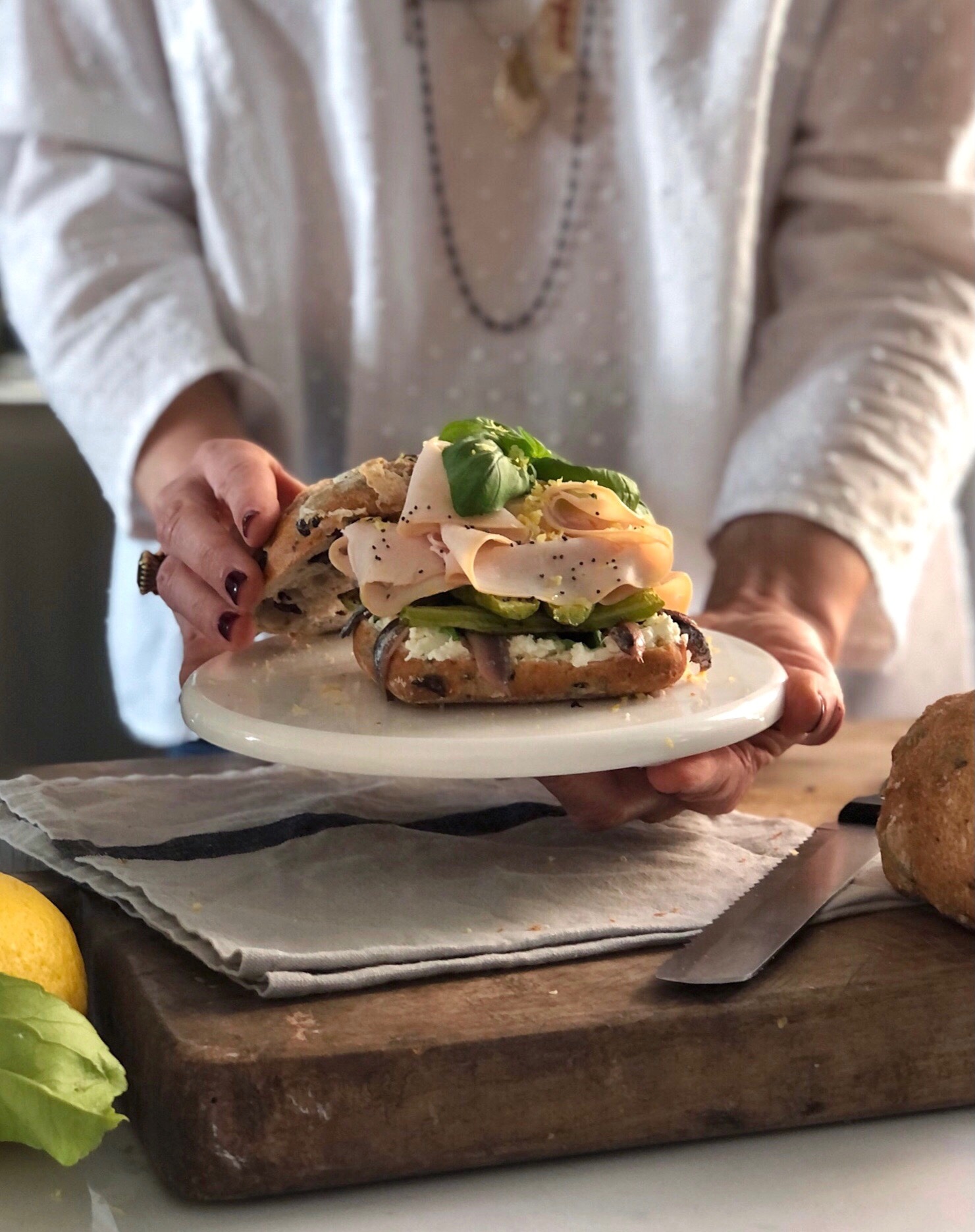 Panino gourmet con trombette, tacchino al forno, acciughe e crema di robiola al basilico