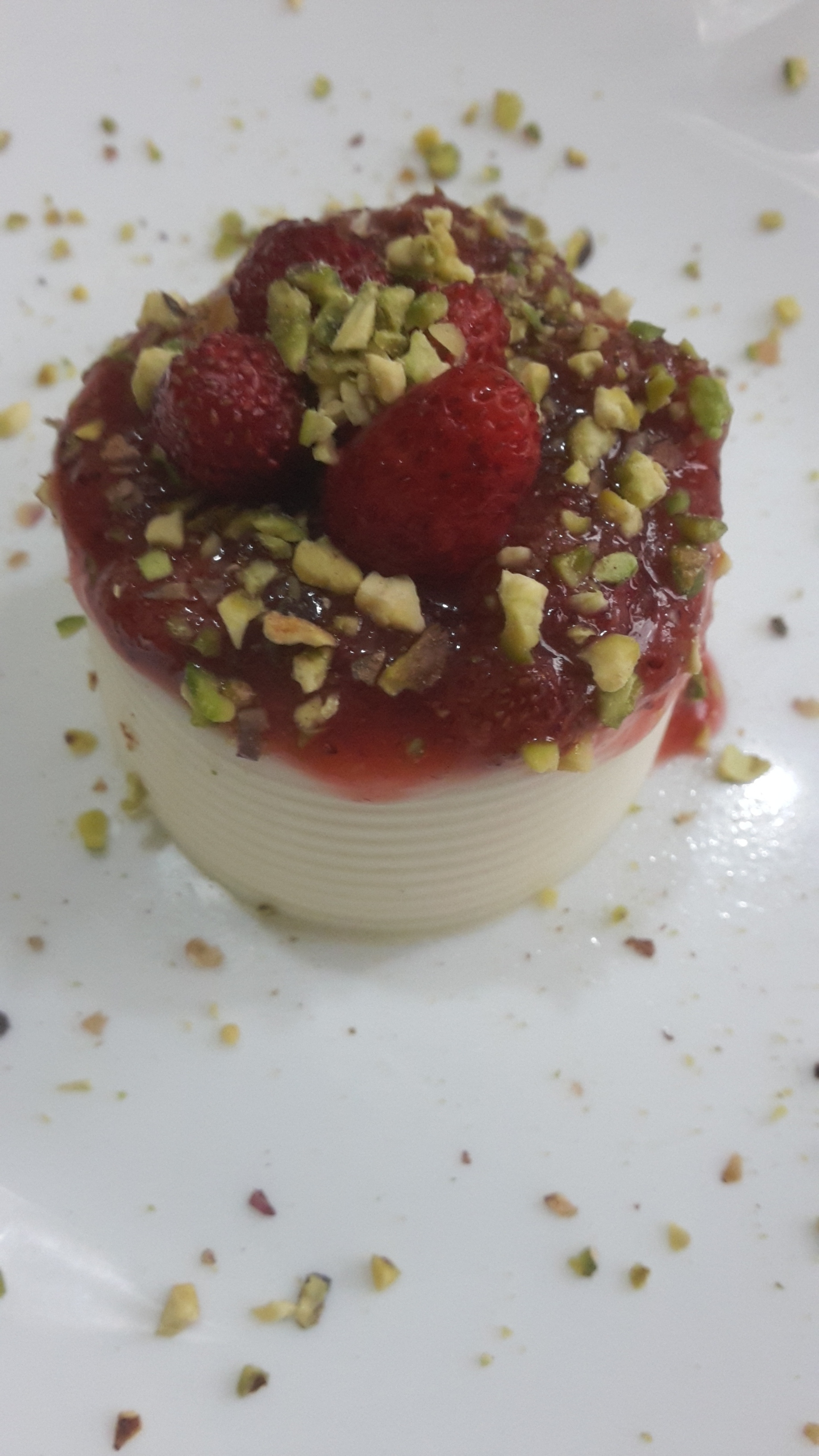 Panna cotta con fragoline di bosco e pistacchio
