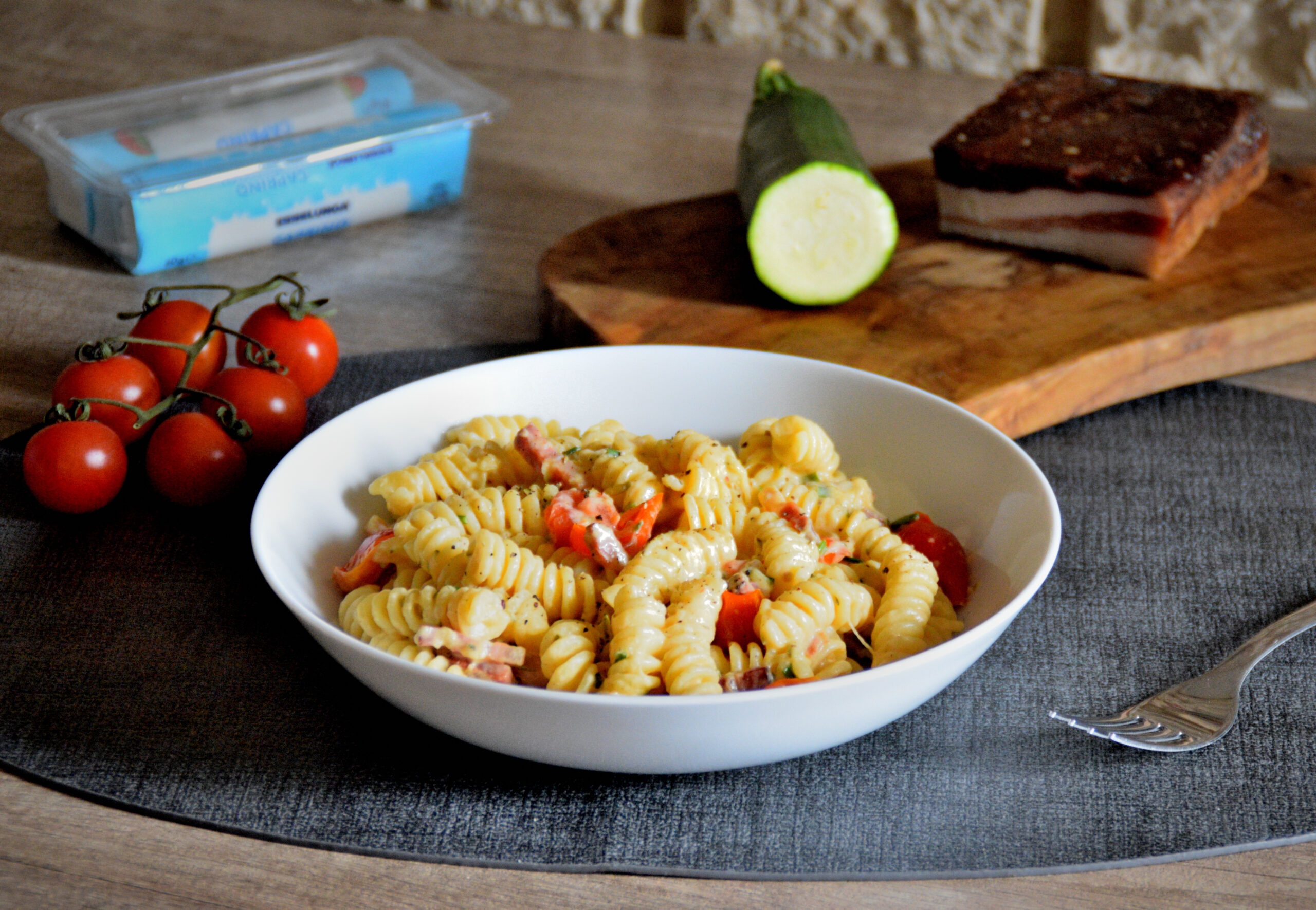 Pasta con caprino, pomodorini, zucchine e pancetta: la ricetta completa
