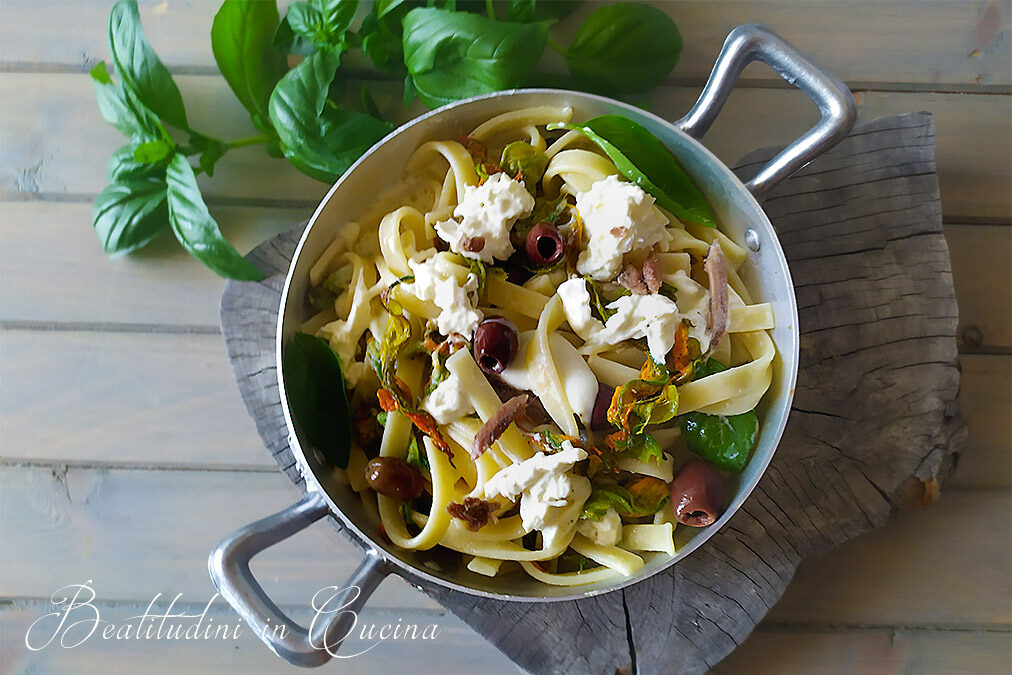 Pasta con fiori di zucca, acciughe, olive e burrata