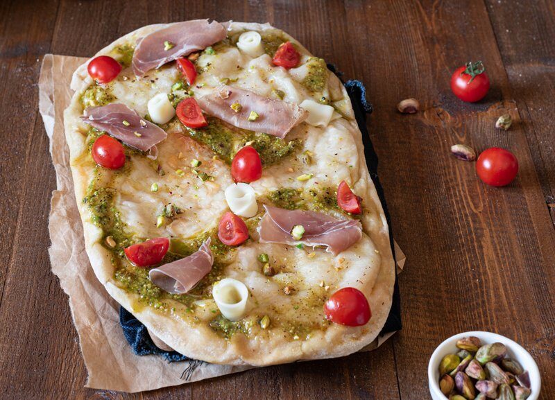 Pinsa con prosciutto crudo mozzarella e pistacchio
