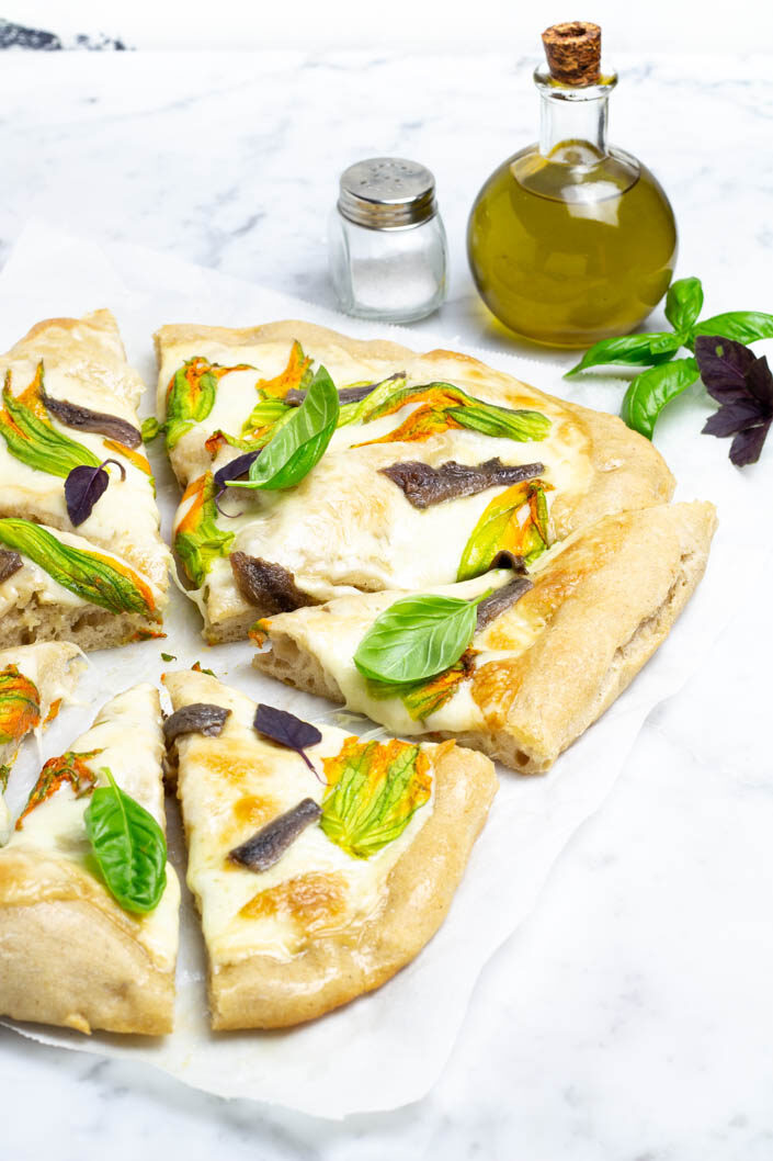 Pizza ai cereali con fiori di zucca e alici