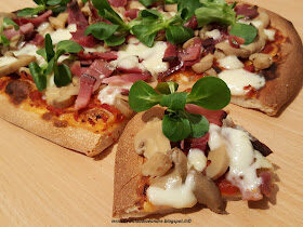 Pizza con pomodoro, speck, funghi champignon, asiago e valeriana