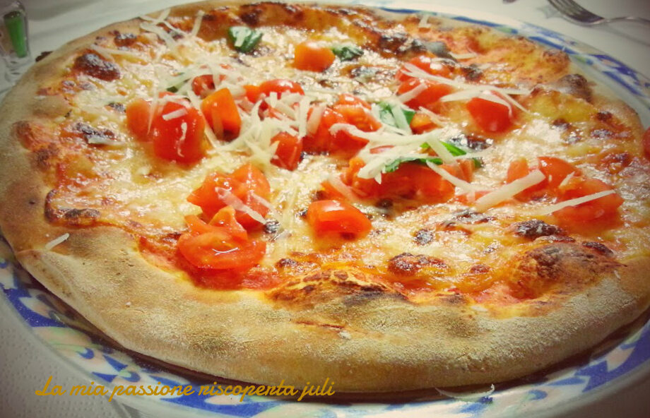 Pizza con scaglie di formaggio e pomodori, mozzarella