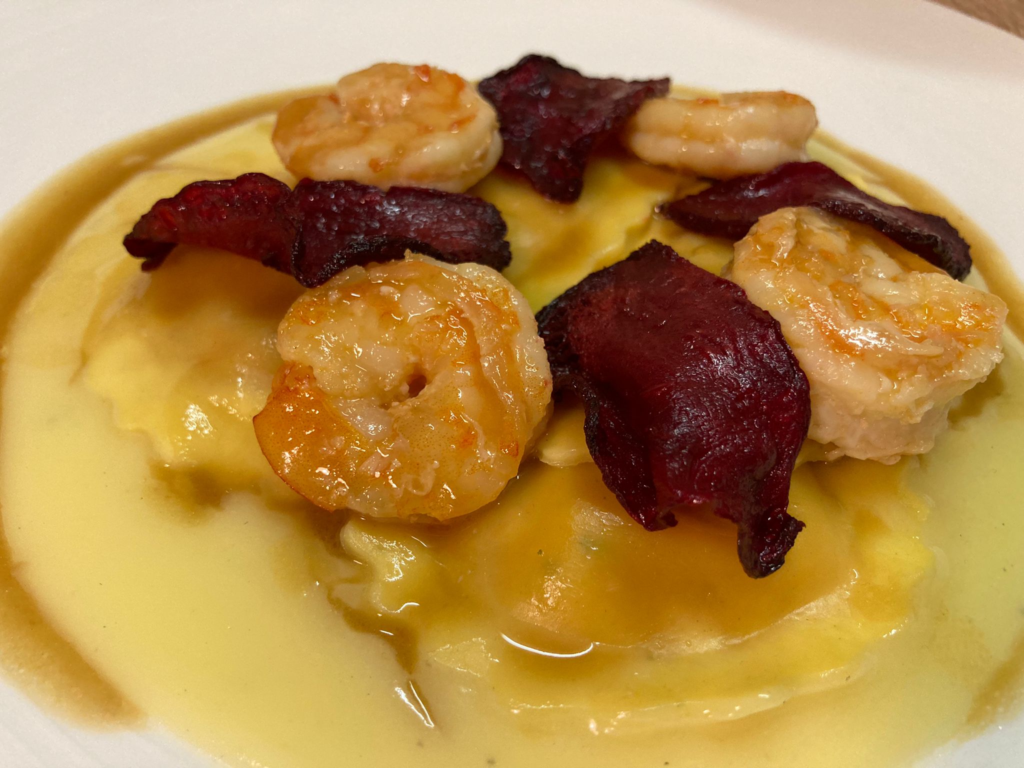 Ravioli all’astice con beurre blanc, mazzancolle e chips di barbabietola