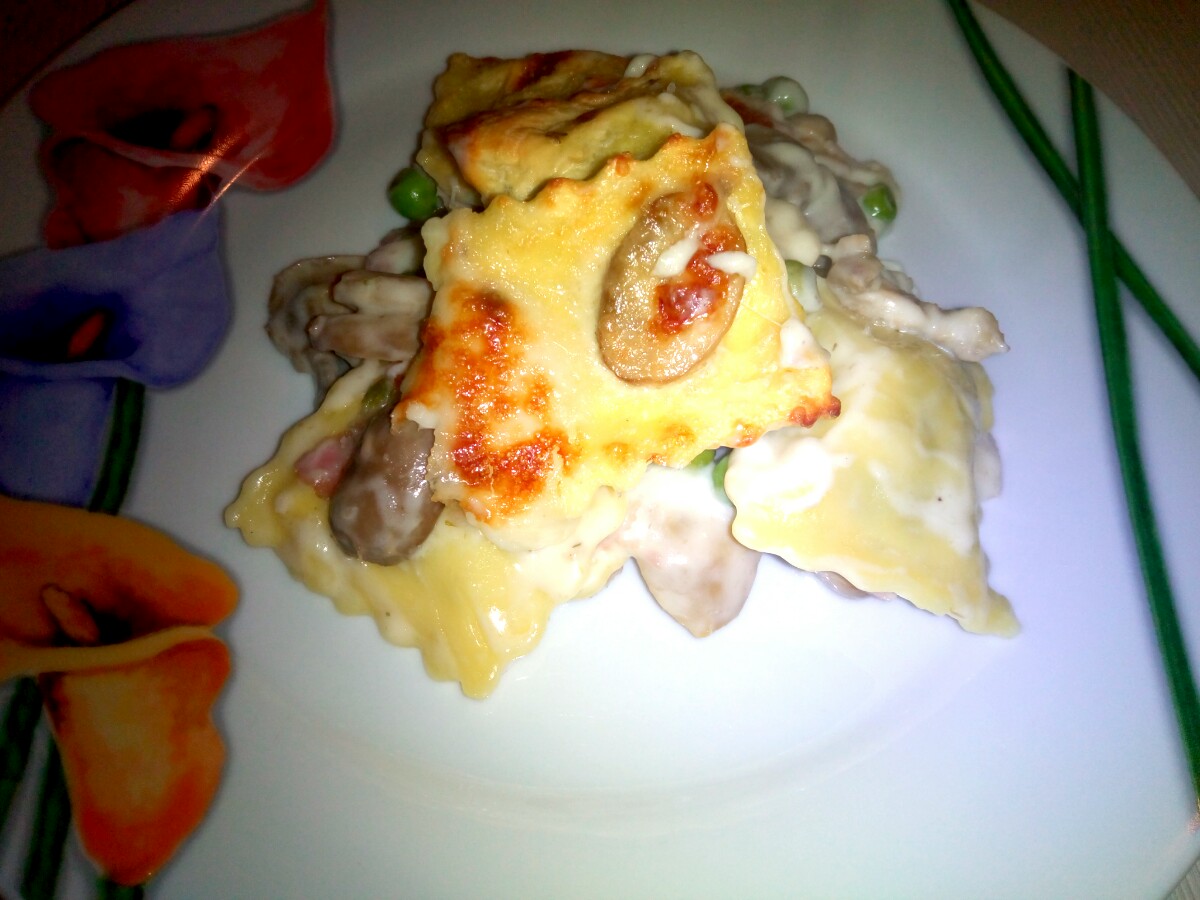 Ravioli gratinati con funghi prosciutto e piselli