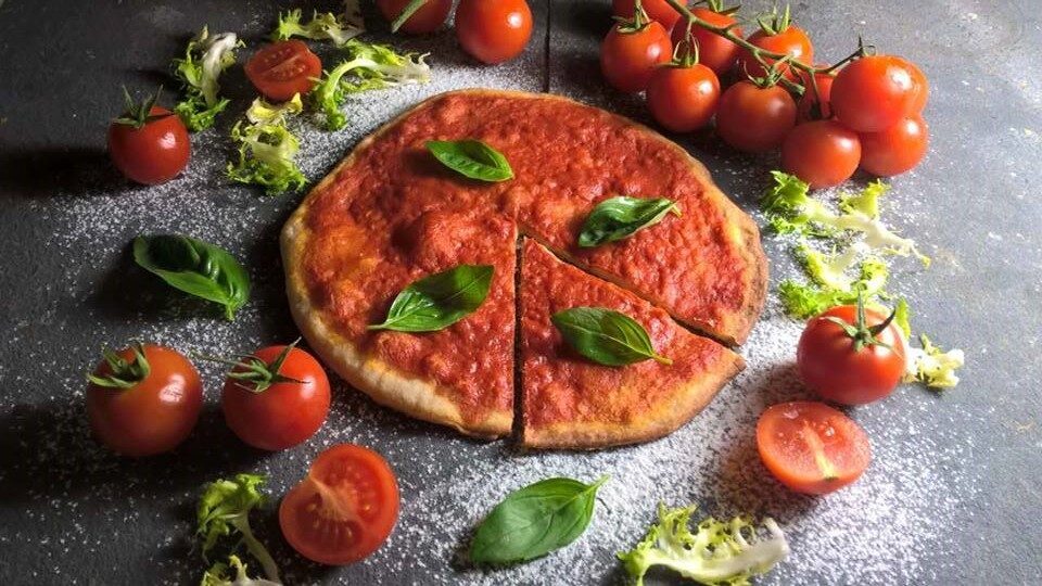 Ricetta pizza  leggera con pomodoro e foglie di basilico