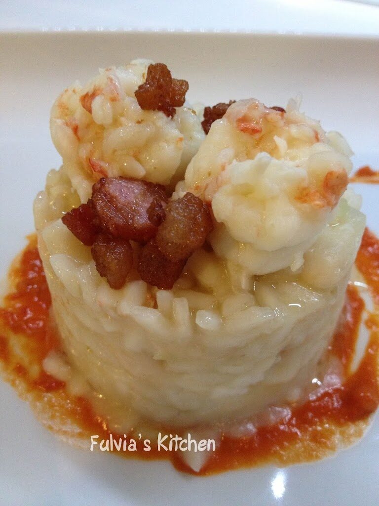 Risotto con scampi e cannellini su letto di datterini confit e coriandoli di guanciale croccante