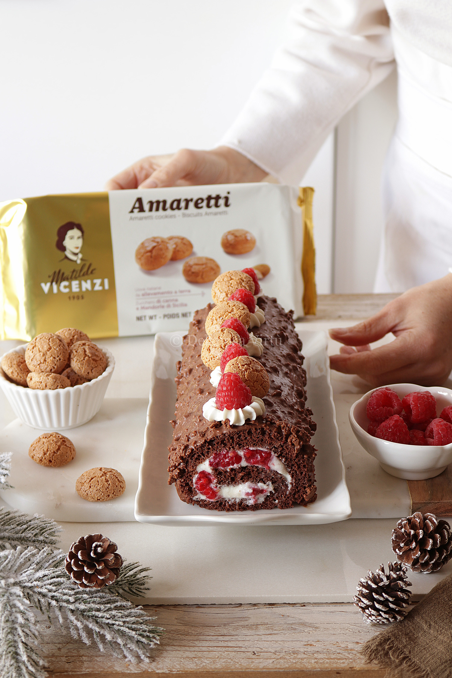 Rotolo al cacao con crema al latte, lamponi e glassa agli amaretti