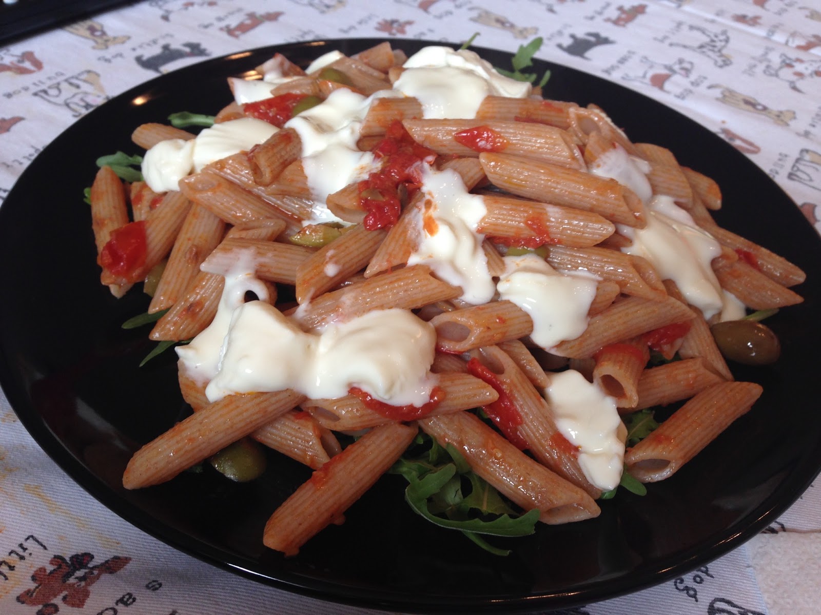 Senza bimby, penne semi integrali al farro con pomodorini, olive veri, olive taggiasche e stracchino su letto di rucola