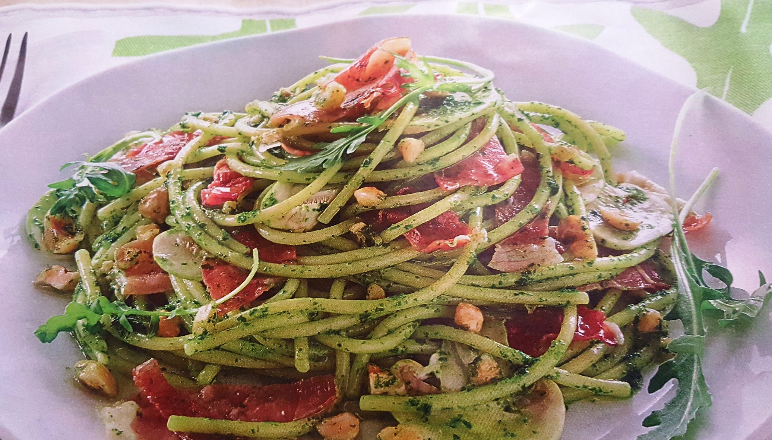 Spaghetti al pesto di rucola speck e funghi champignon