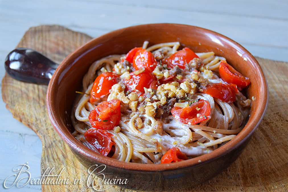 Spaghetti con pesto di acciughe, noci e limone su crema di burrata