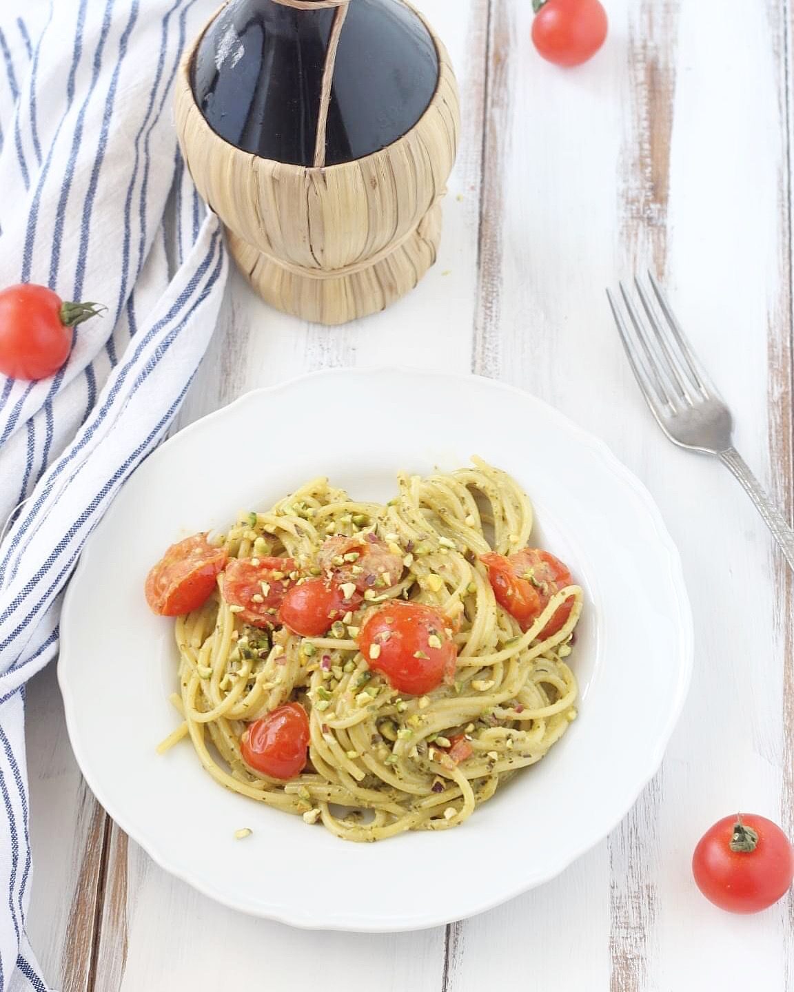 Spaghetti con pomodorini, pesto e granella di pistacchi