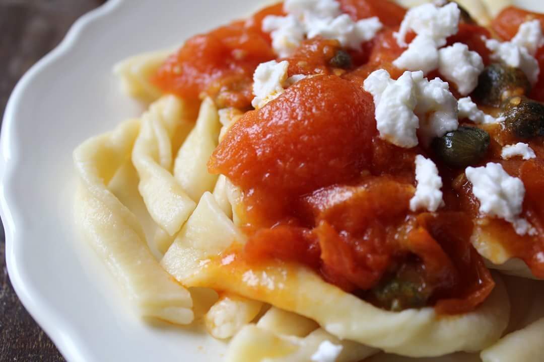 Strozzapreti con pomodori, capperi e formaggio