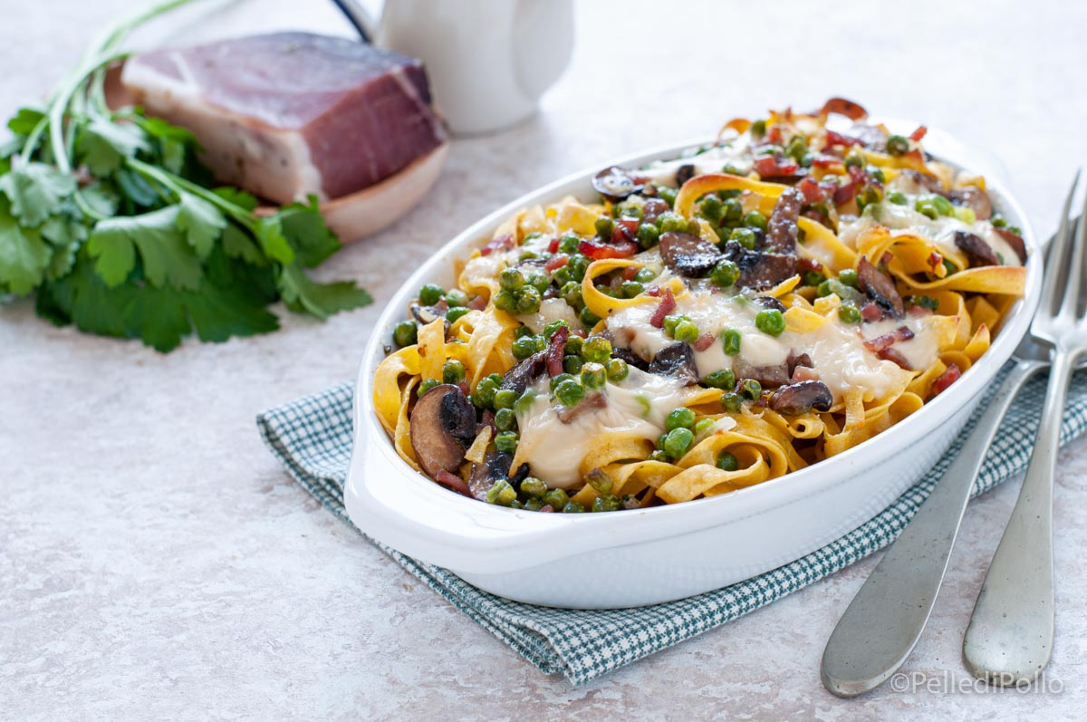 Tagliatelle al forno con piselli, funghi e speck