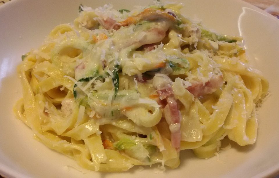 Tagliatelle cremose con fiori di zucca e speck