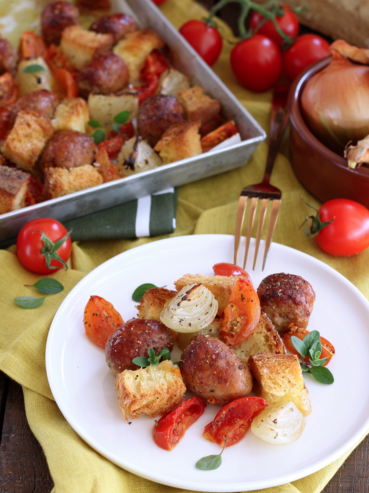 Teglia furba di salsicce con pomodori, cipolle e pane raffermo